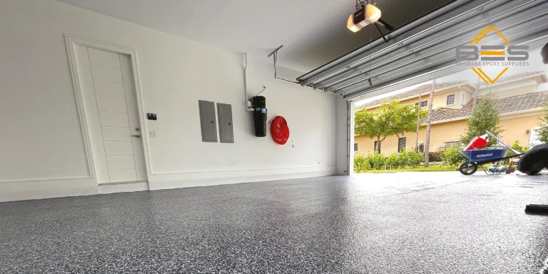 A wide shot showcasing a beautifully finished epoxy flake floor in a modern, clean garage setting. The image should highlight the seamlessness and reflective quality.